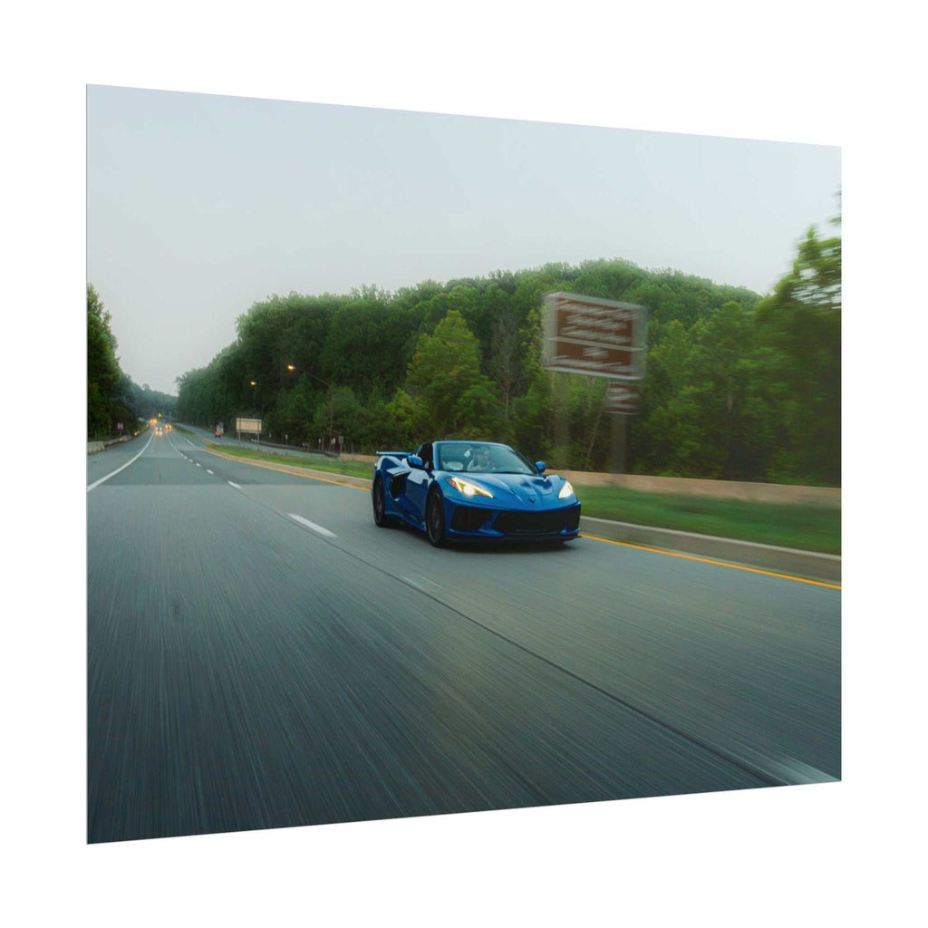 C8 Corvette Stingray in blue with sleek design and prominent headlights speeding on highway with motion blur