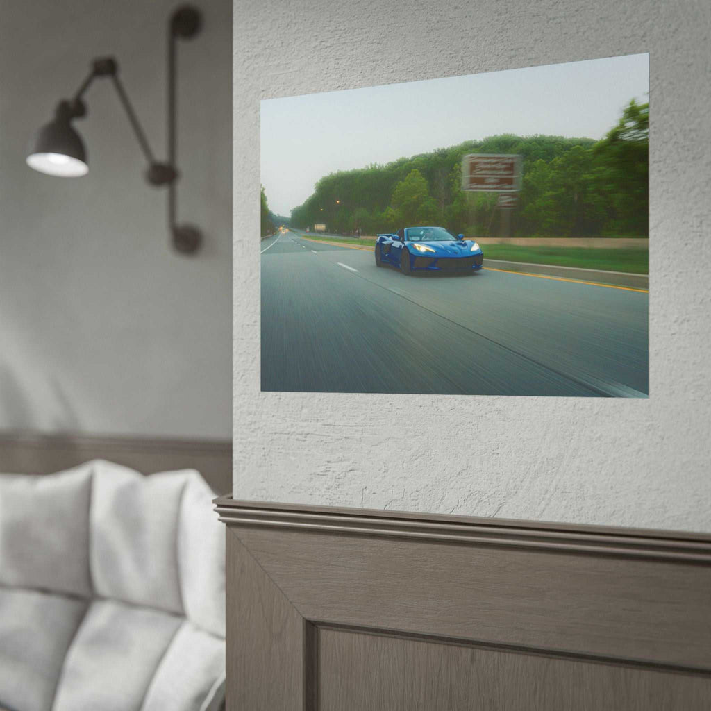 C8 Corvette Stingray blue sports car driving on a tree-lined highway with motion blur capturing speed and depth