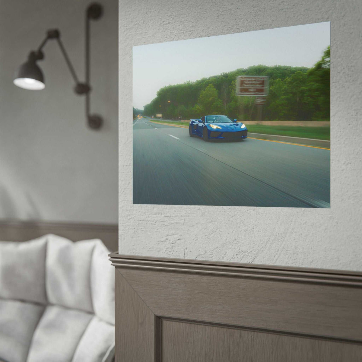C8 Corvette Stingray blue sports car in motion on a highway with green trees and speed blur effect
