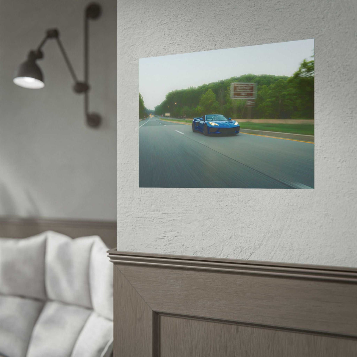 C8 Corvette Stingray blue sports car speeding on a tree-lined highway with motion blur capturing dynamic motion