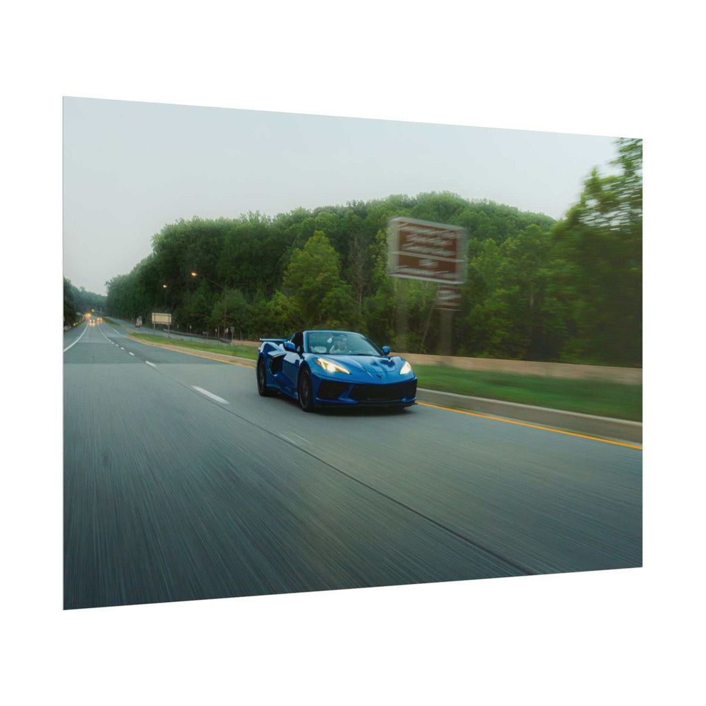 C8 Corvette Stingray blue sports car driving on a tree-lined highway with motion blur and crisp highlights