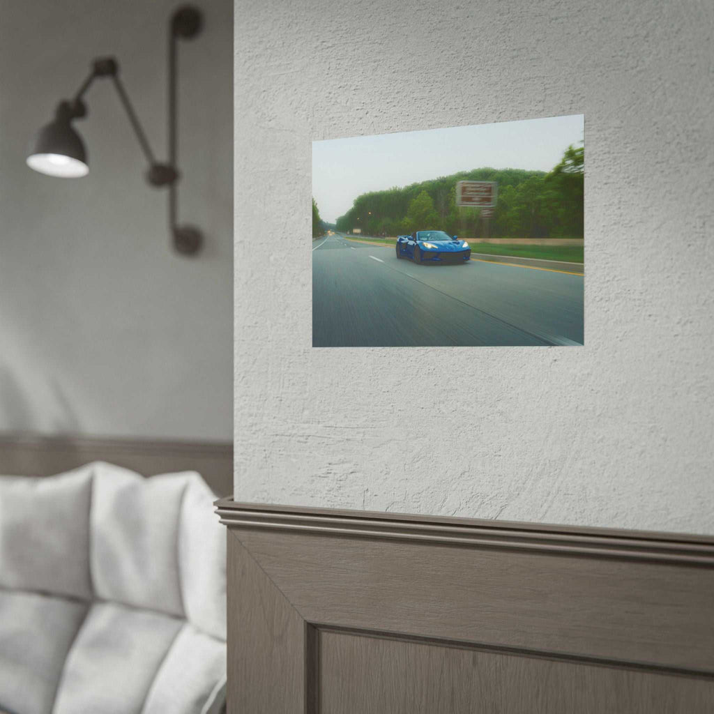Blue C8 Corvette Stingray sports car speeding down a tree-lined highway with motion blur on a rolled photography print