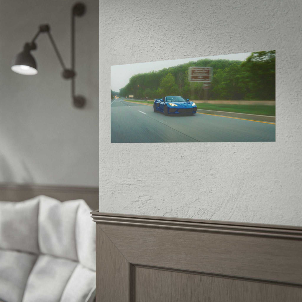 C8 Corvette Stingray blue sports car speeding on tree-lined highway with motion blur and vivid colors in framed print