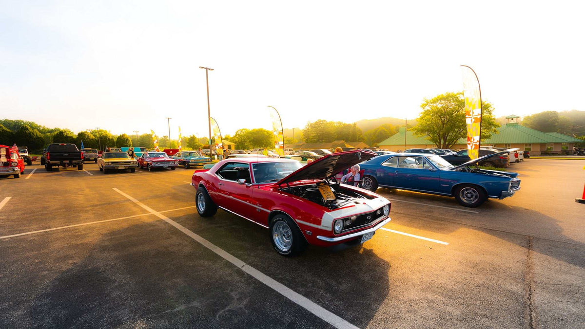 Classic red muscle car with its hood open exhibiting a shiny engine at a car show enhanced by Dreamy Glow Lightroom Preset golden lighting