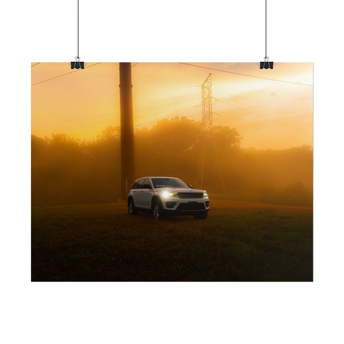 Jeep Grand Cherokee in white driving through warm, hazy sunset fog with power lines in the background, creating a cinematic mood