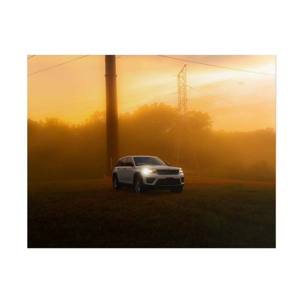 Jeep Grand Cherokee in white driving through warm orange sunset fog with power lines in background