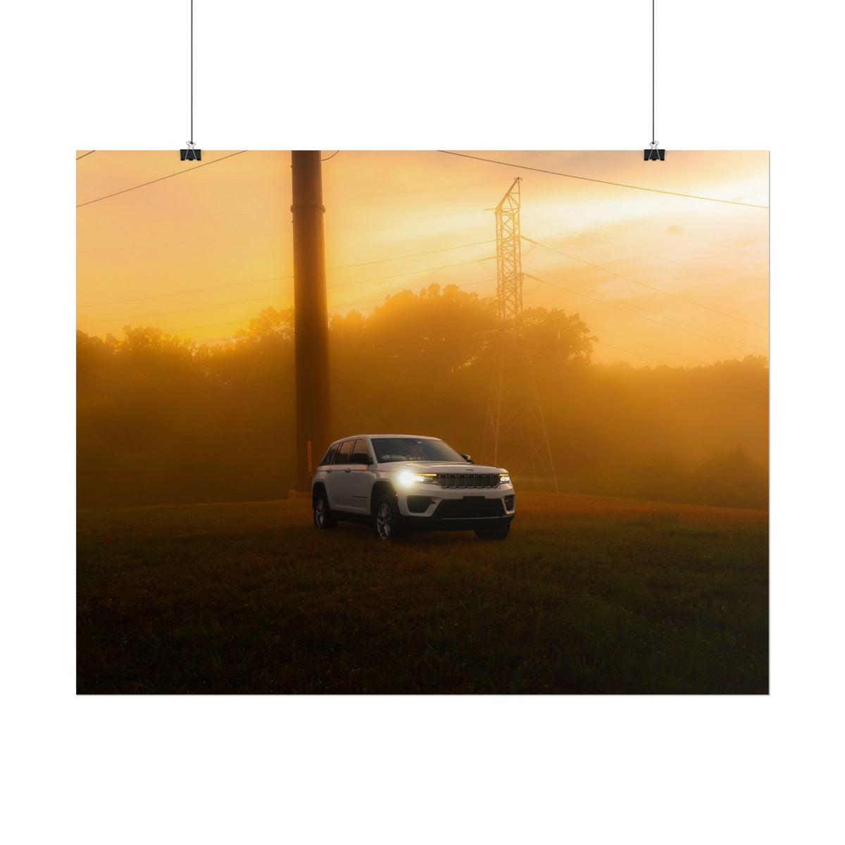 Jeep Grand Cherokee in white with headlights on, driving through warm, hazy sunset fog with power lines in background