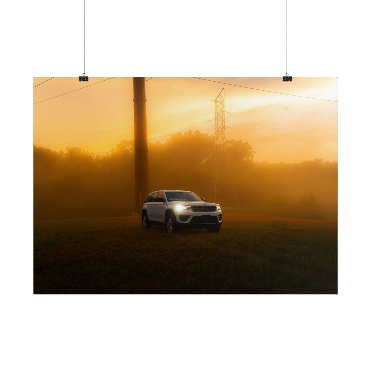 Jeep Grand Cherokee white SUV with headlights on driving through amber sunset fog with power lines in background