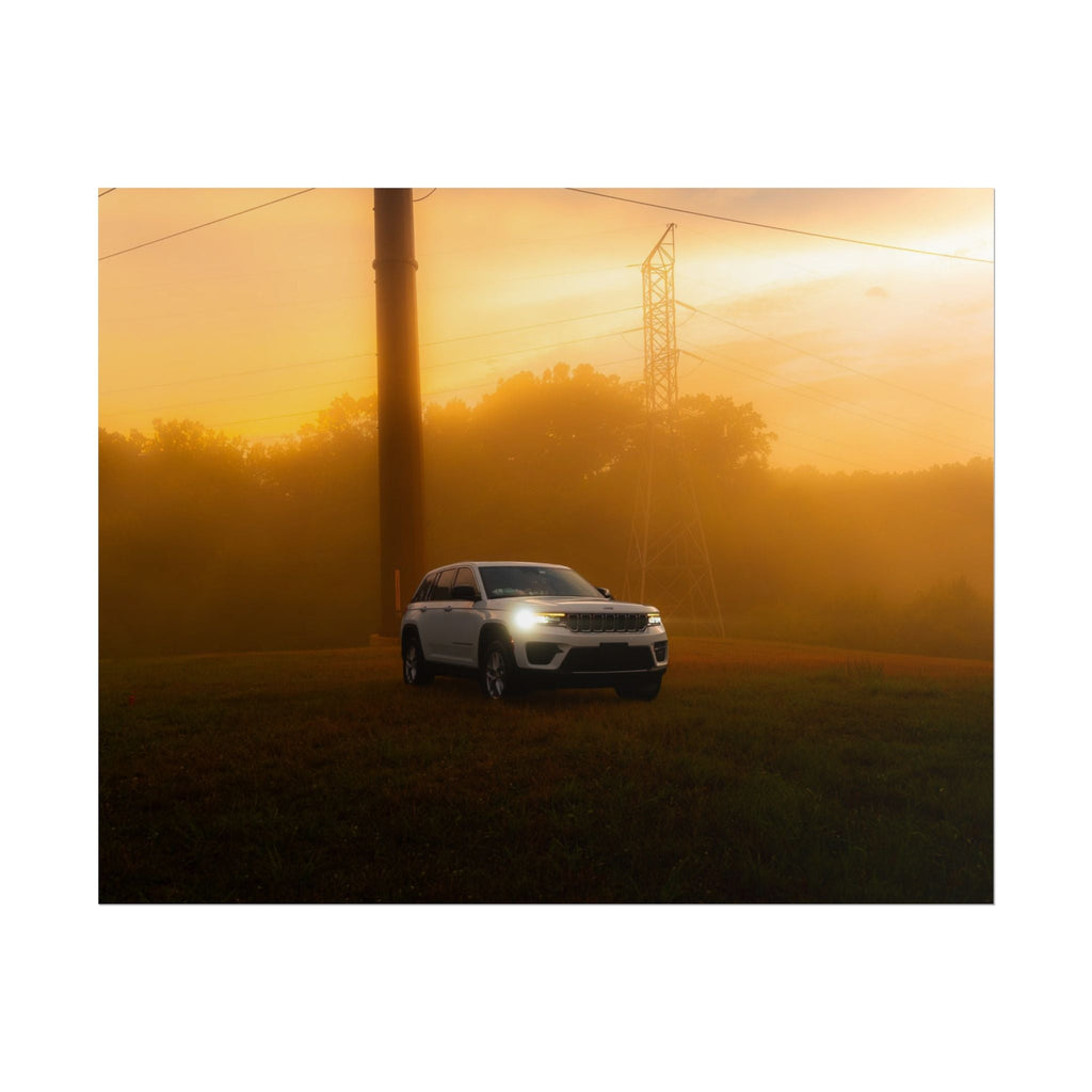 Jeep Grand Cherokee white SUV with headlights on in warm amber sunset fog on grassy field near power lines