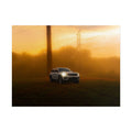 Jeep Grand Cherokee white SUV parked on grassy field with warm orange sunset fog and tall utility poles in background
